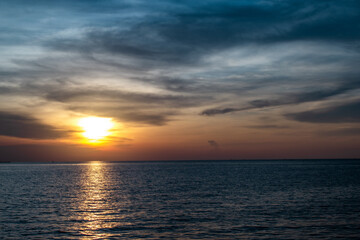 The sunset shines brightly on the sea, the dark black sky is beautiful.