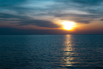 The sunset shines brightly on the sea, the dark black sky is beautiful.