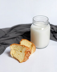White milk drink served with bread is good for breakfast in the morning. This fresh cow's milk in addition to its sweet taste also contains many nutrients. warm milk in a glass cup.