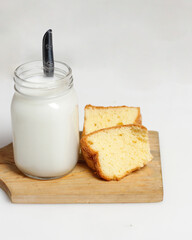 White milk drink served with bread is good for breakfast in the morning. This fresh cow's milk in addition to its sweet taste also contains many nutrients. warm milk in a glass cup.