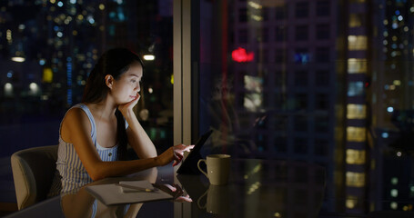 Woman work on the tablet computer at office in the evening
