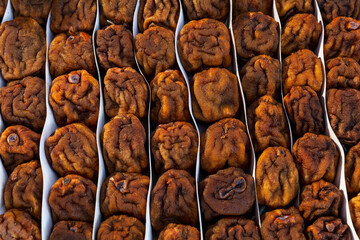 Dried persimmons on the market counter. Seasonal oriental tasty and healthy fruit. Close-up.