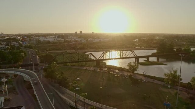 Right to left looking towards the city drone shot of an old train bridge, an iconic place in the capital of the state of Sinaloa, Culican.