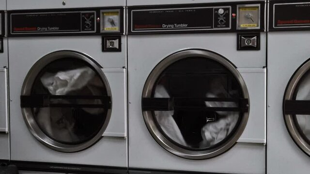 Multiple laundry machines spinning in slowmotion. 100 fps.