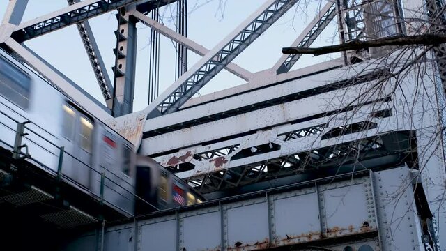 NYC subway train goes above on elevated tracks and trestle, in upper Manhattan