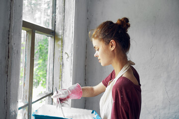 woman with brush paint window home renovation interior
