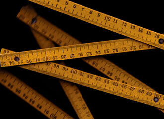 Vintage wooden yellow meter on a black background. Ruler, centimeter, numbers/