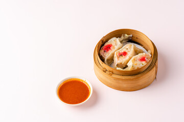 Top View of Assorted Chinese Dimsum in bamboo basket. Dimsum is a large range of small dishes that Cantonese people traditionally enjoy in restaurants for breakfast and lunch.