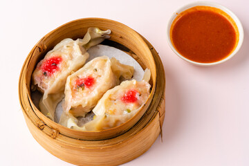 Top View of Assorted Chinese Dimsum in bamboo basket. Dimsum is a large range of small dishes that Cantonese people traditionally enjoy in restaurants for breakfast and lunch.