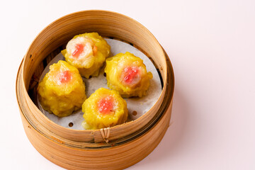 Top View of Assorted Chinese Dimsum in bamboo basket. Dimsum is a large range of small dishes that Cantonese people traditionally enjoy in restaurants for breakfast and lunch.