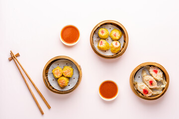 Top View of Assorted Chinese Dimsum in bamboo basket. Dimsum is a large range of small dishes that Cantonese people traditionally enjoy in restaurants for breakfast and lunch.