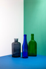 Still life with glass bottles on a colored background