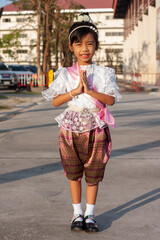 Asian little girls wearing traditional costume thai style to paying respect with a bright smile, activity at school.