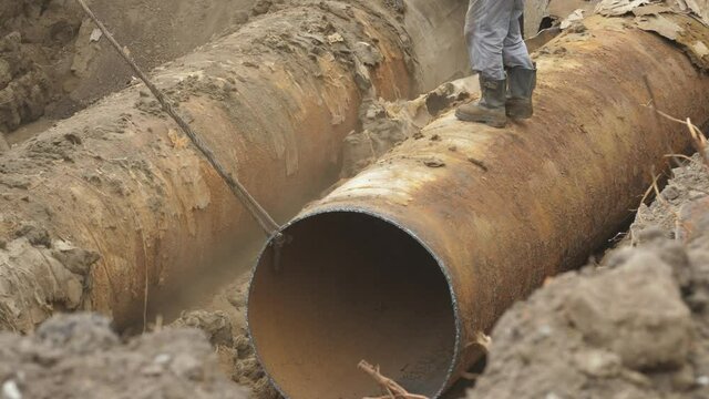 Underground heating rust pipeline in trench. Insulated steel pipe in deep trench. Repair rusted heating system, thermal pipe insulation