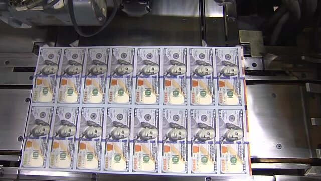 SHEET OF 100 DOLLAR BILLS AT PRINTING PRESS WIDE SHOT