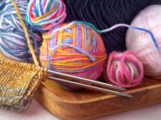 Multi-colored wool for knitting. Knitting needles.