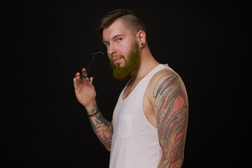 bearded man in white t-shirt with tattoos on his arms posing bully