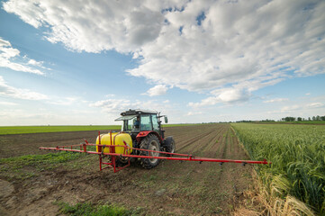 Tractor spraying soil in field