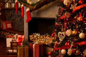 Christmas room. Beautifully decorated Christmas tree on the background of the fireplace, santa socks, boxes with gifts.