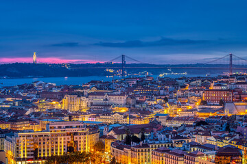 Fototapeta na wymiar The lights of Lisbon in Portugal with the Sanctuary of Christ the King and the 25 de Abril Bridge
