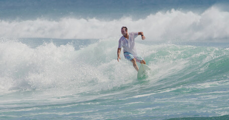 Surfer surfing in tropical ocean wave