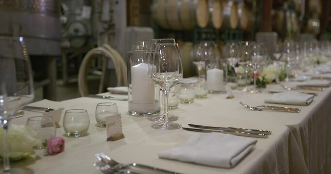 Empty large rectangle white wedding table full of crockery and cutlery