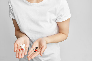 woman pills in hand pain reliever light background