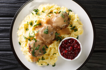 Scandinavian Meatball Lihapullat with mashed potatoes and lingonberry jam close-up in a plate on the table. Horizontal top view above
