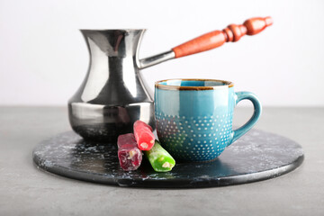 Board with cup, cezve and Turkish delight on table