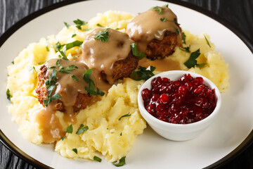 Meatballs Lihapullat with mashed potatoes and lingonberry jam close-up in a plate on the table. Horizontal