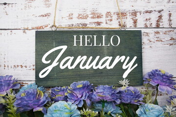 Happy January typography text decorate with flower on wooden background