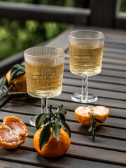 Tangerines with leaves on a dark background. Glass of wine. Christmas background.