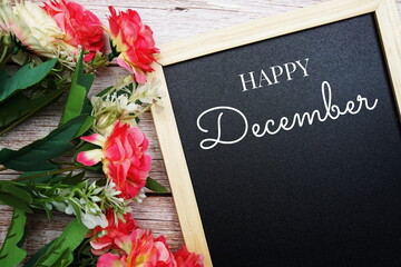 Happy December text on blackground decorated with flower bouquet on wooden background