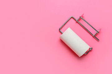Holder with empty toilet paper tube on pink background