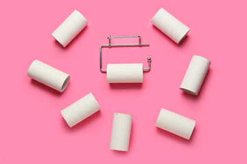 Holder with toilet paper tubes on pink background