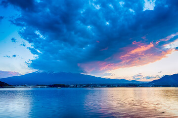 Kawaguchiko Lake in Front of Japanese Fuji Mountain with Bridge and Fishing Boats in Foreground in Japan.