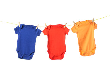 Rope with colorful baby bodysuits on white background