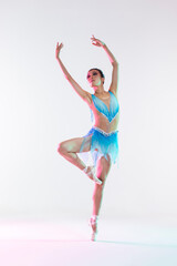 Fototapeta na wymiar Classical Ballet Concepts. Young Professional Japanese Female Ballet Dancer Posing in Pale and Blue Dress With Flying Cloth In Hands Against White Background.