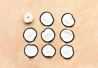 Reusable cotton pads and flower on color background