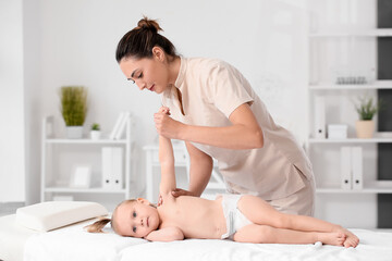 Massage therapist working with baby in medical center