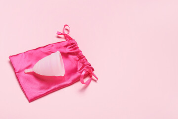 Menstrual cup with bag on pink background
