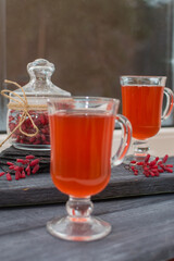 Barberry drink in glass glasses on a gray wooden surface.