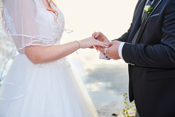 Groom wears a wedding ring on the bride's hand