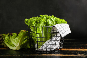 Basket with fresh lettuce on dark wooden table