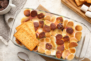 Baking dish with delicious S'mores dip on light background
