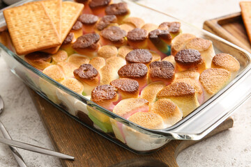 Baking dish with tasty S'mores dip on light background, closeup