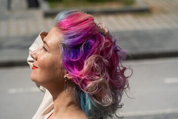 Close-up portrait of curly Caucasian woman with multi-colored hair. Model for hairstyles