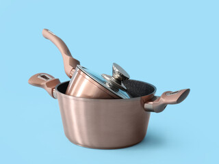 Cooking pots on color background