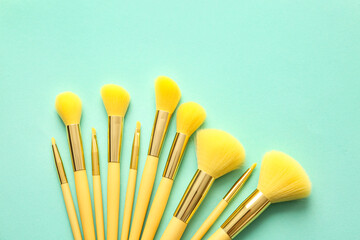 Different makeup brushes on color background