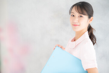 美容系ナースや看護師のイメージに使いやすいアジア人女性のポートレート　コピースペースあり ピンクの前ボケあり